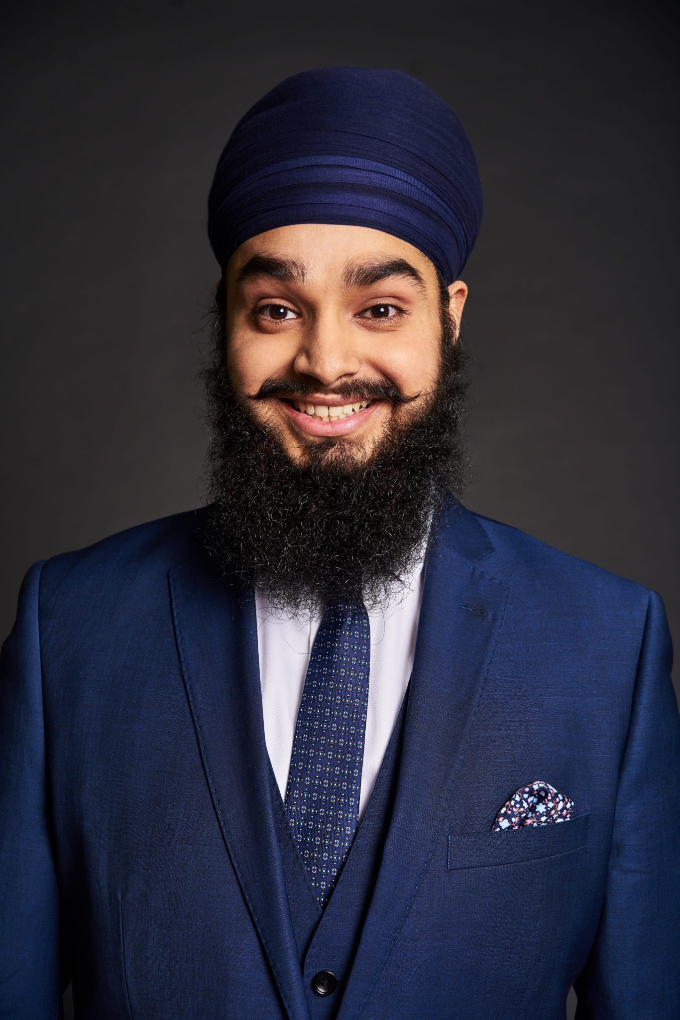 BT Legends Studio Photography Bearded man in navy suite and turban smiling at the camera