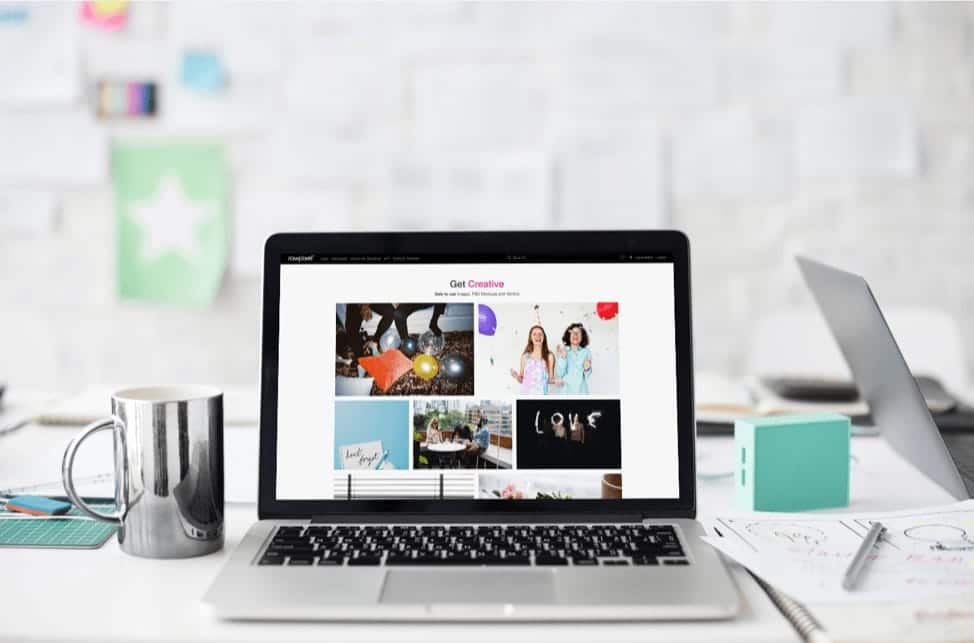 An open laptop in a creative home studio showing Get Creative website