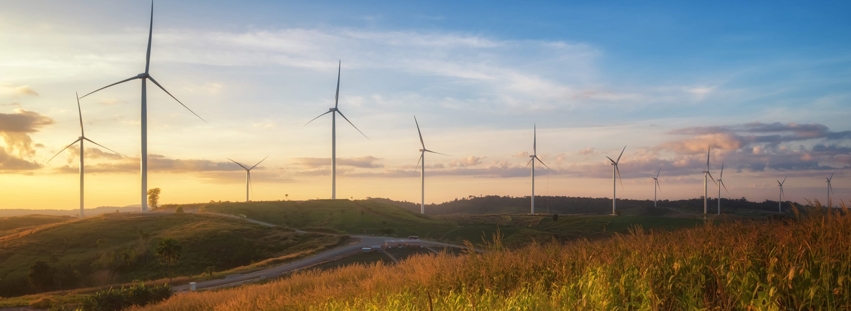 Wind turbines on grassy hills and sunrise