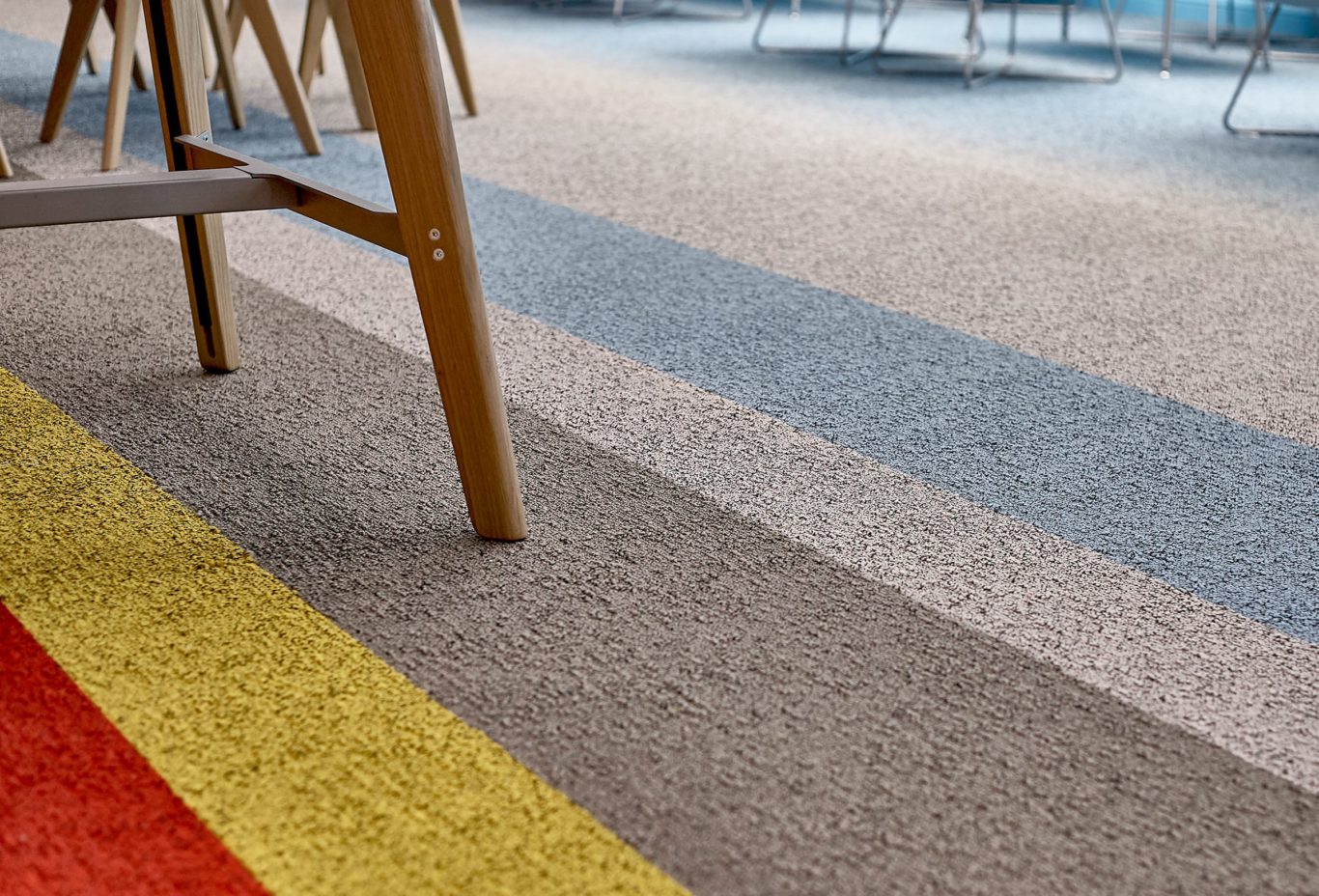 E.on Interiors, branded environment.closeup of wooden stool legs and brand colours carpet