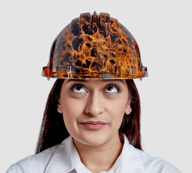 Head and shoulders phto of Hanson Employee Arti wearing a hard hat with a photo of flames on it