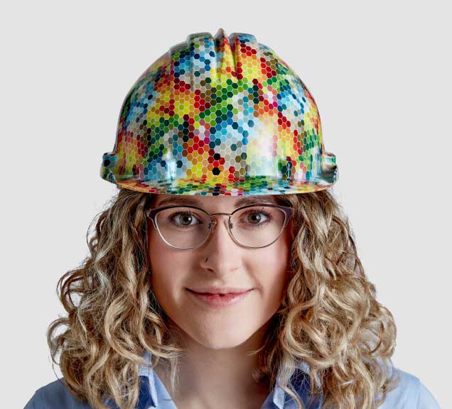 Head and shoulders phto of Hanson Employee Jenna wearing a hard hat with a rainbow geometric pattern on it